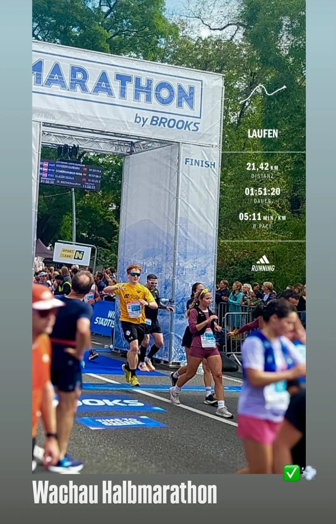 Clemens läuft im gelben Laufshirt durch den Zielbogen des Wachau-Halbmarathons, daneben die Laufdaten 21,42 Kilometer in 1:51:20 Stunden